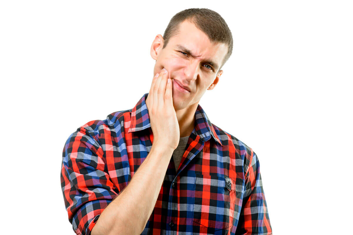 Man holding his cheek due to a toothache